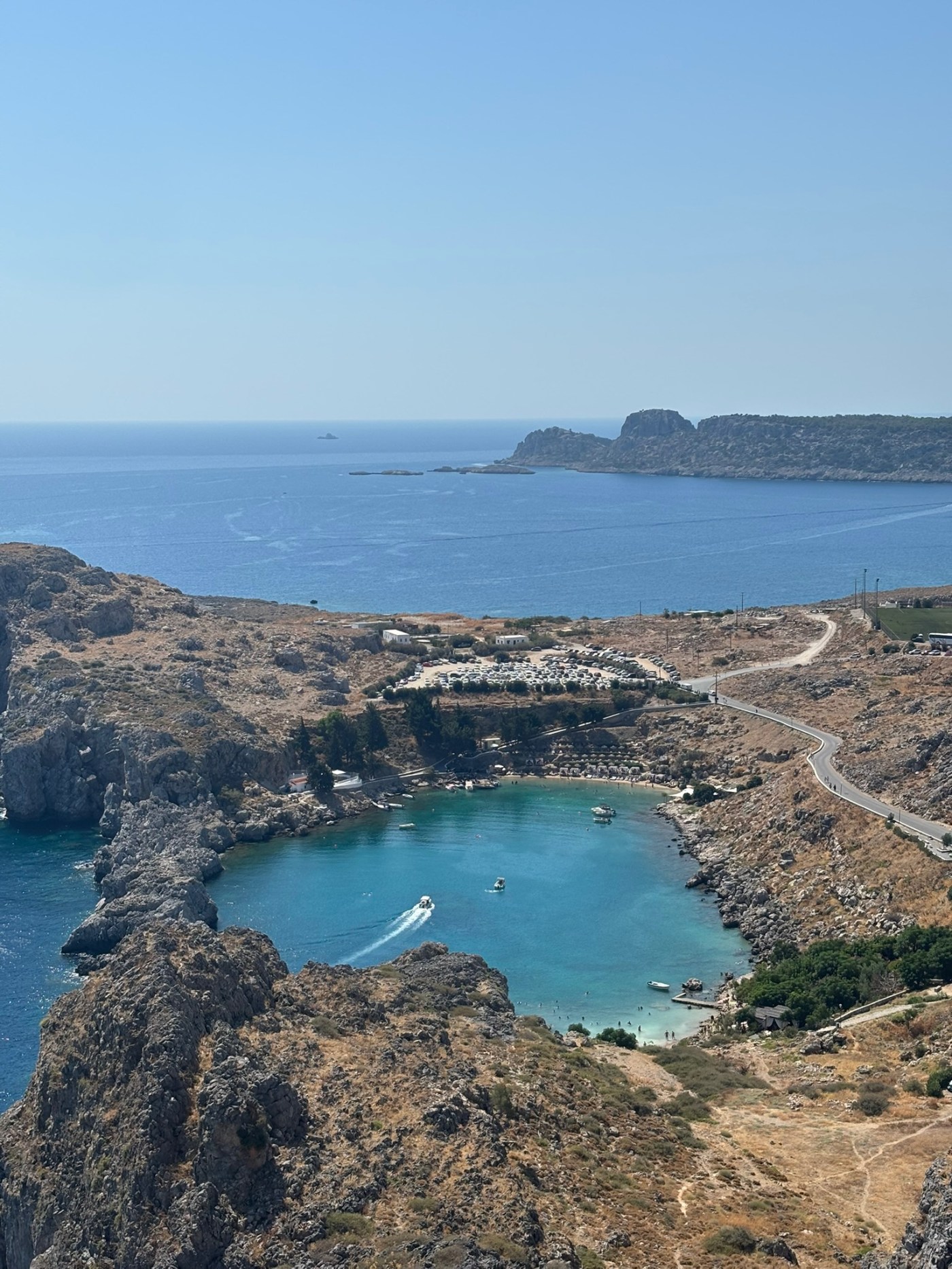 St Paul’s Bay in Rhodes with turquoise water surrounded by rocky cliffs near Lindos, Greece